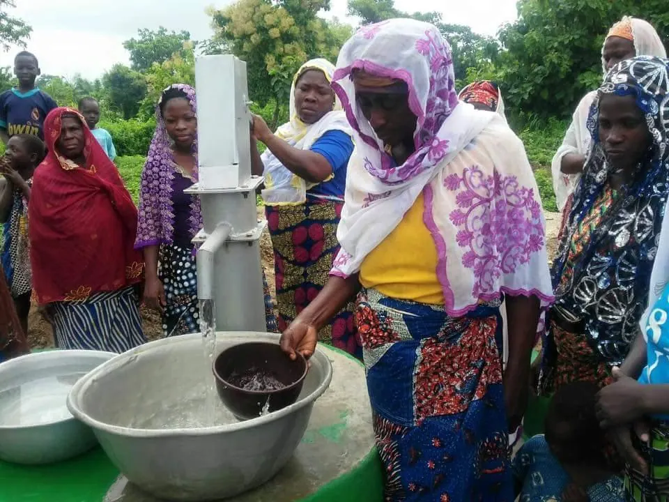 A woman draws water from a village pump