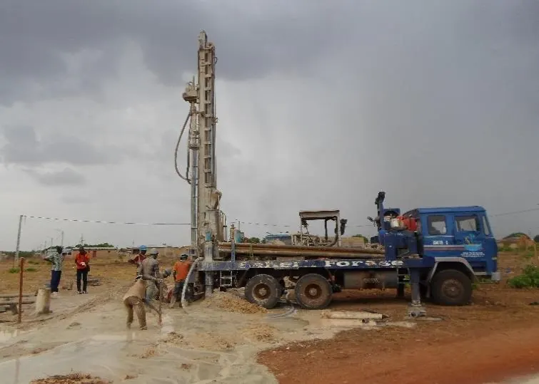 The drilling mast raised for a hydraulic borehole