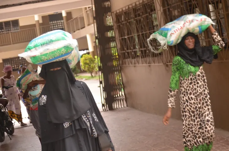 A woman leaves with her bag of rice